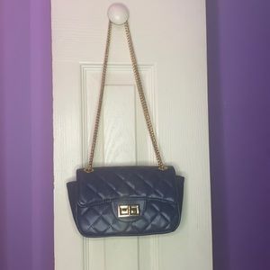 A blue purse with a gold chain